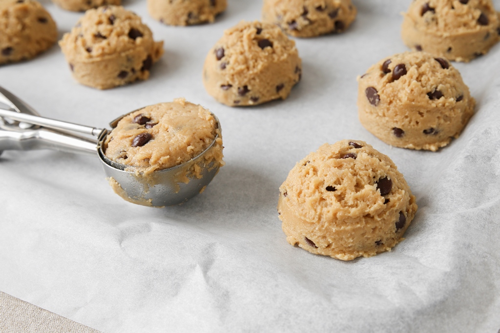 Scoops of oatmeal chocolate chip cookie dough on a baking sheet with a cookie scoop – Yummy Cooking Treats