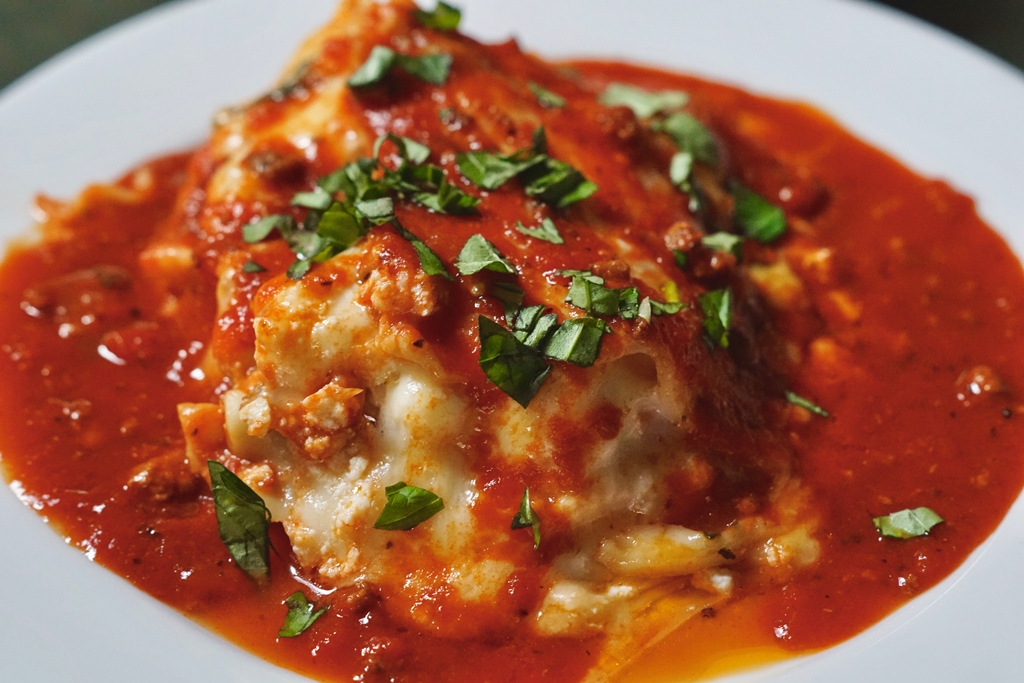Chicken parmesan with marinara sauce and herbs on a rustic plate – a signature comfort dish from Yummy Cooking Treats