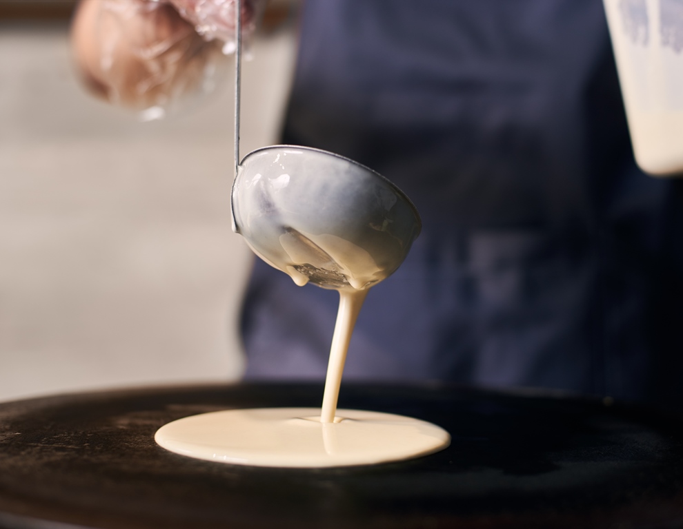A ladle pouring almond flour pancake batter onto a hot griddle during cooking – Yummy Cooking Treats