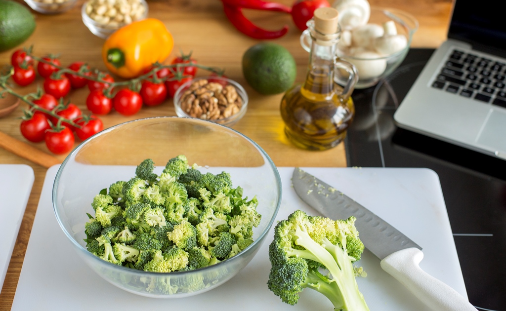 Fresh broccoli slaw prep with veggies, olive oil, and nuts on a kitchen counter – Yummy Cooking Treats healthy cooking scene