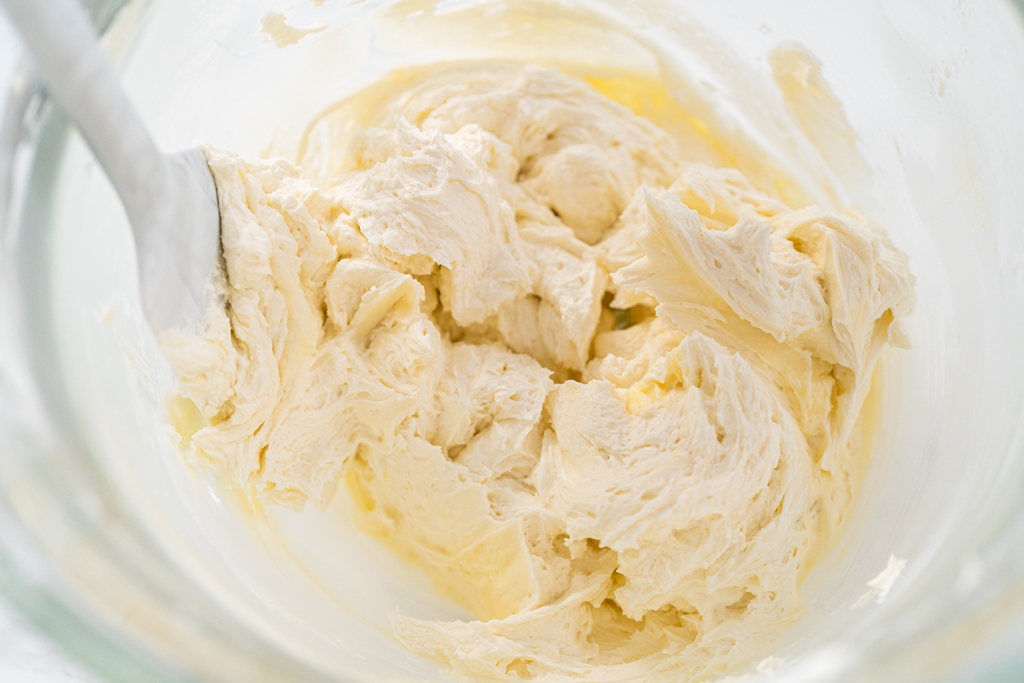 Close-up of creamy ice cream base being mixed in a glass bowl with a spatula – Yummy Cooking Treats