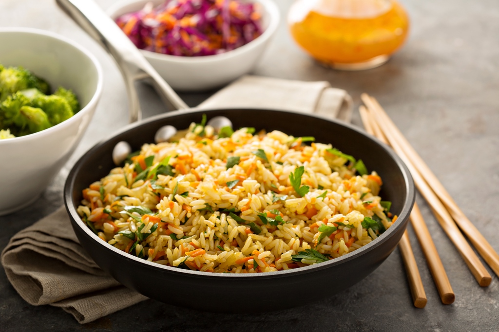 A steaming bowl of egg fried rice with chopped veggies, garnished with parsley—served fresh and hot by Yummy Cooking Treats