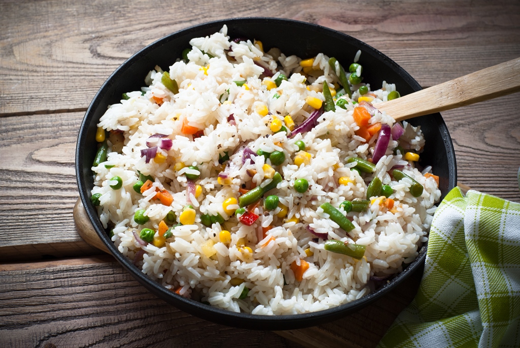 Freshly stir-fried vegetable rice in a black skillet with corn, peas, carrots, and green beans—recipe by Yummy Cooking Treats